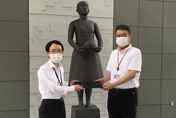 愛知県公立大学法人 総務部 吉川部長（左）に
パソコンを手渡す当社総務部長 小池（右）